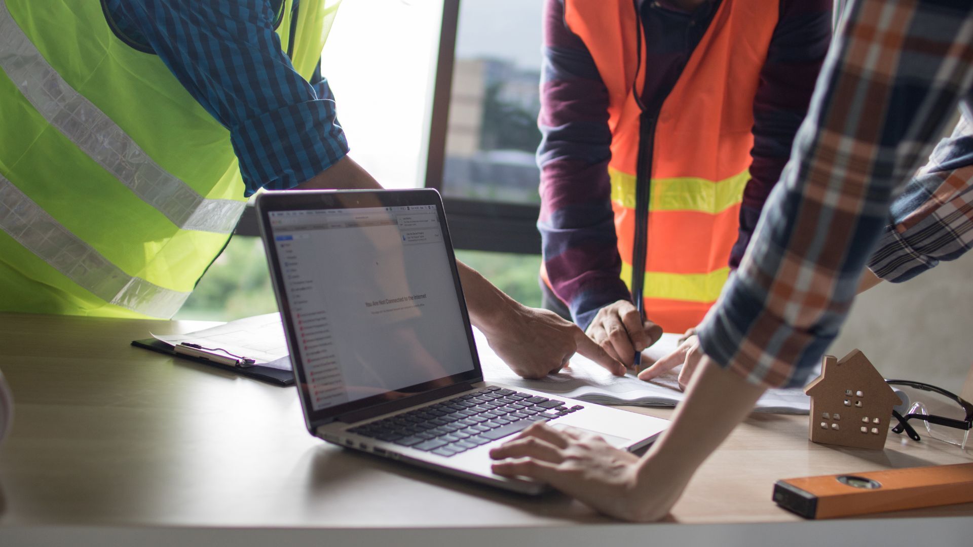 A group of people working in field service, around a laptop